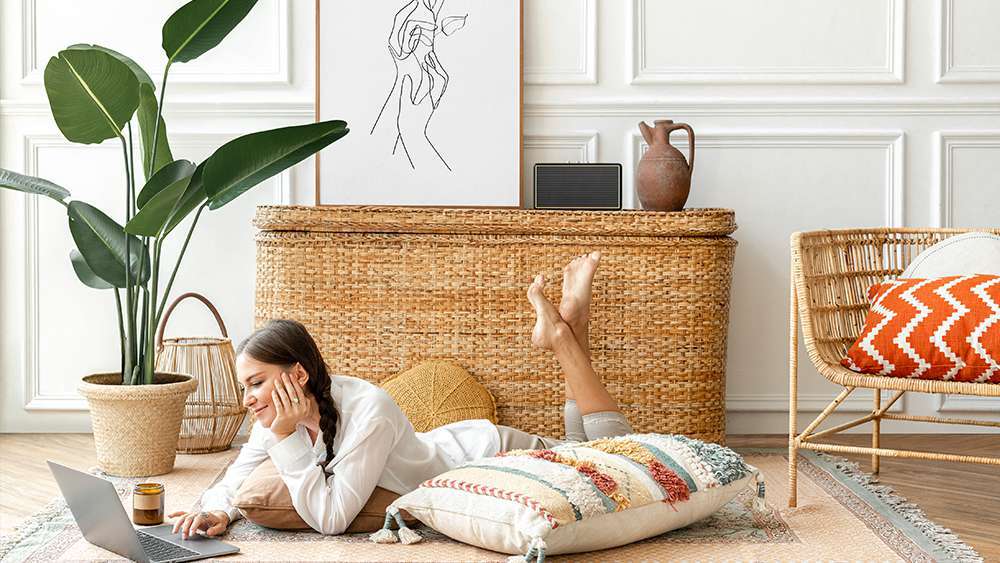 A girl working on her laptop beside a giant rubber tree