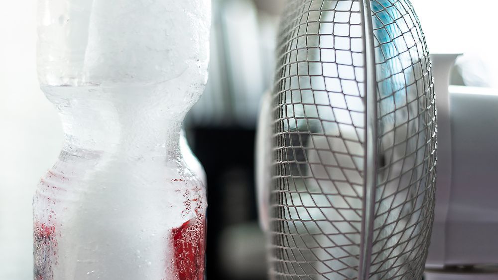 A fan with a block of ice to cool down a dorm room