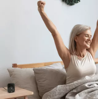 Woman waking up to a perfect home temperature as breez eco black implements her morning schedule.