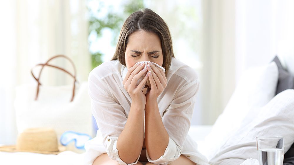 Woman having nasal allergy attack. Focusing on MERV rating is important to avoid health complications due to poor indoor air quality.