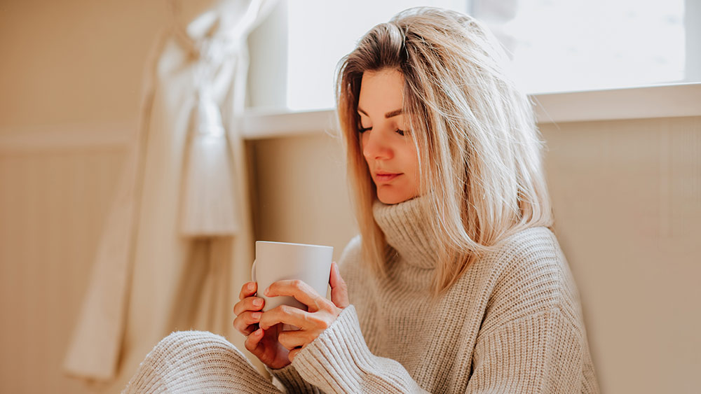 woman sitting and drinking warm tea