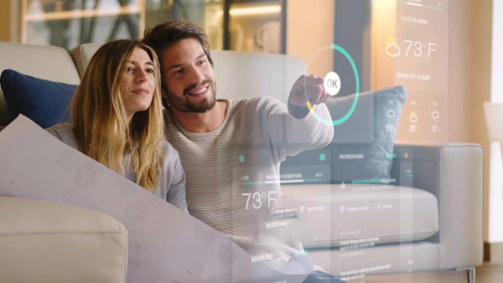 man woman changing smart thermostat settings