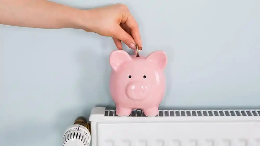 Man putting a coin in piggy bank.