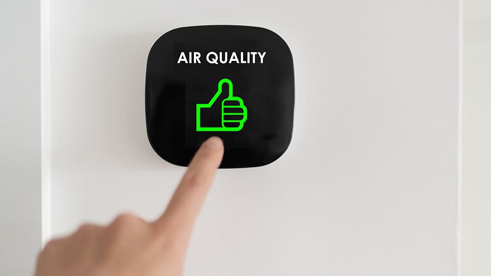An air purifier showing that indoor air quality status is good with green thumbs up
