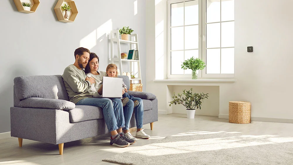 family sitting in living room with max device on the wall