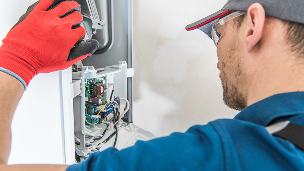 A person cleaning furnace during annual maintenance