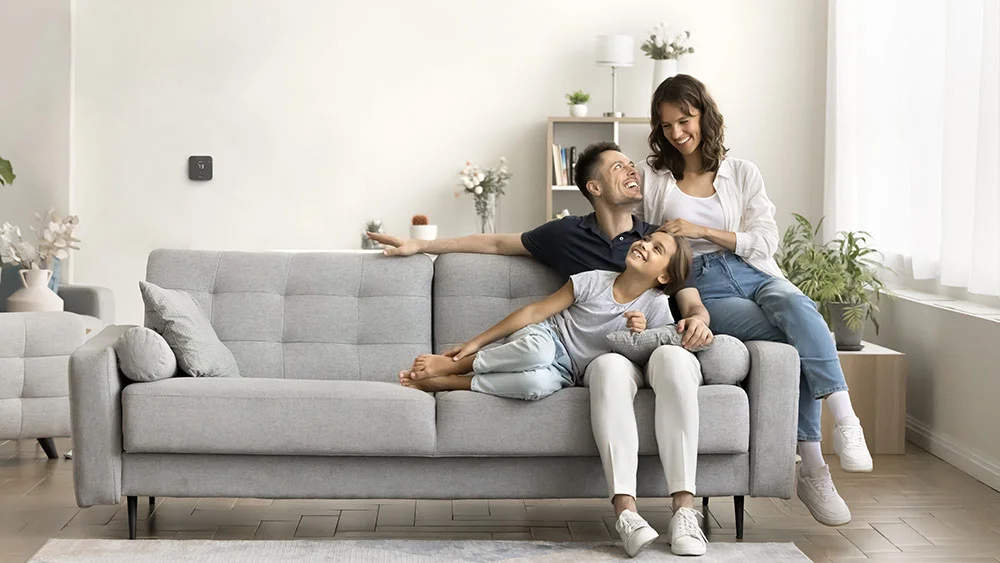 family sitting together and laughing in living room with max on the wall