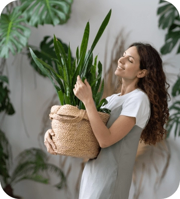 Woman walking with a plant at home